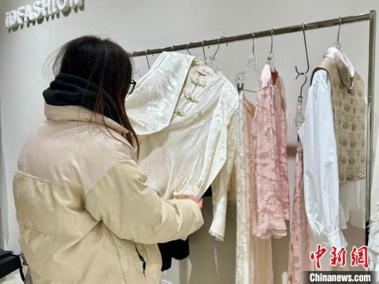圖為一名顧客正在挑選“新中式”服裝。朱瑩 攝 圖為一名顧客正在挑選“新中式”服裝。朱瑩 攝